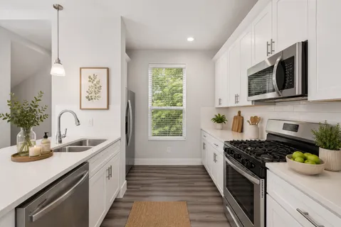 a kitchen with sink a stove and cabinets