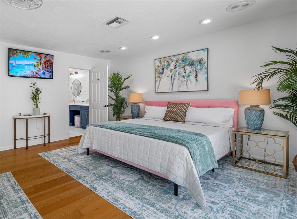 2153 Karan Way Clearwater, FL 33763 - Photo 32 of 65 a bedroom with a bed a painting on the wall and a potted plant
