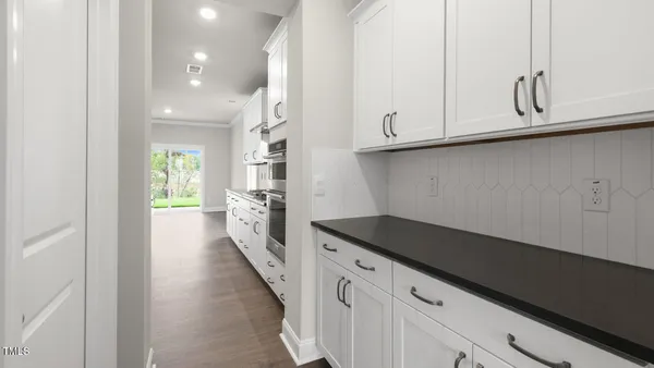 a kitchen with granite countertop white cabinets and sink