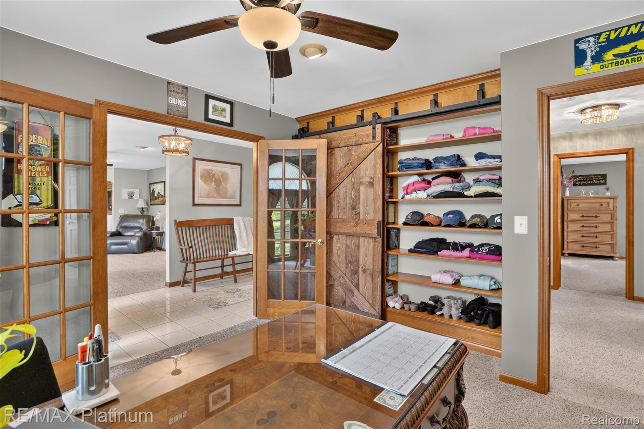 4457 Bradley Road Gregory, MI 48137 - Photo 69 of 79 Picture of 3rd bedroom as an office featuring wood-finish French doors, a built-in shelving unit with barn door hardware, a ceiling fan with integrated lighting, and neutral wall paint