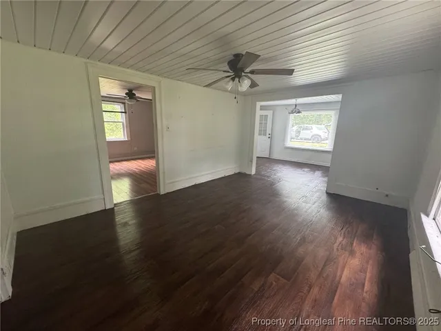 an empty room with wooden floor and entrance
