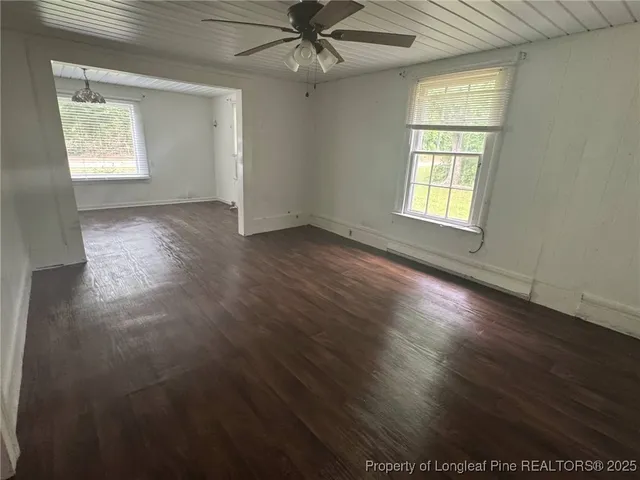a view of a room with wooden floor and a ceiling fan