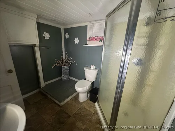 an empty room with wooden floor and ceiling fan
