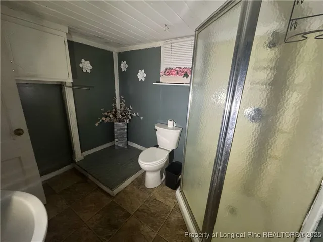 an empty room with wooden floor and ceiling fan