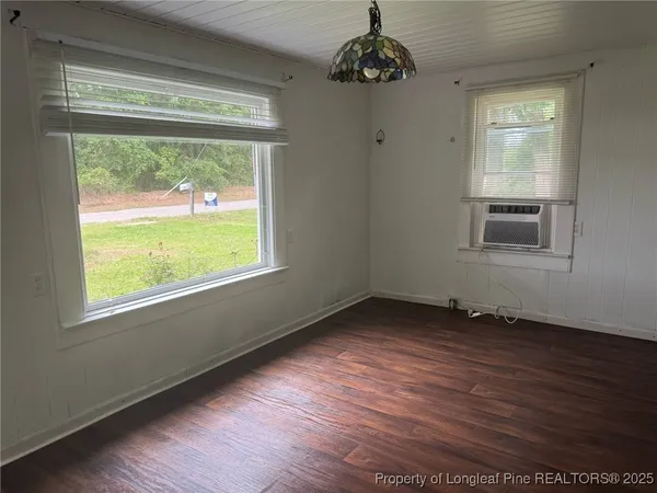 a view of a hallway with wooden floor and a window