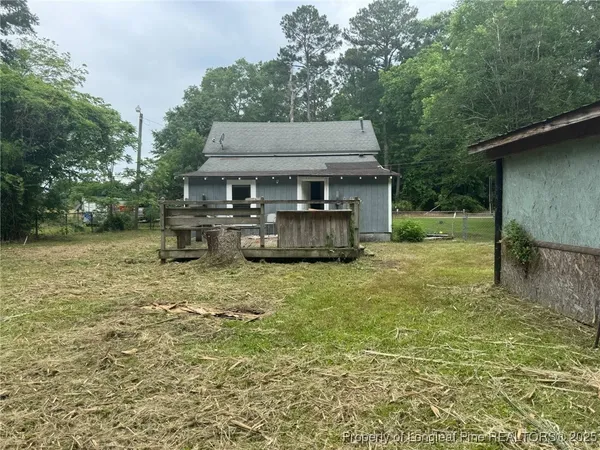 a backyard of a house with barbeque oven and outdoor seating
