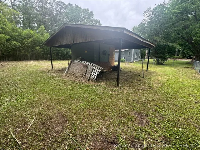 a view of a small house in a big yard with large trees
