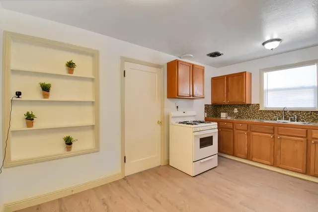 a kitchen with granite countertop white cabinets and white appliances