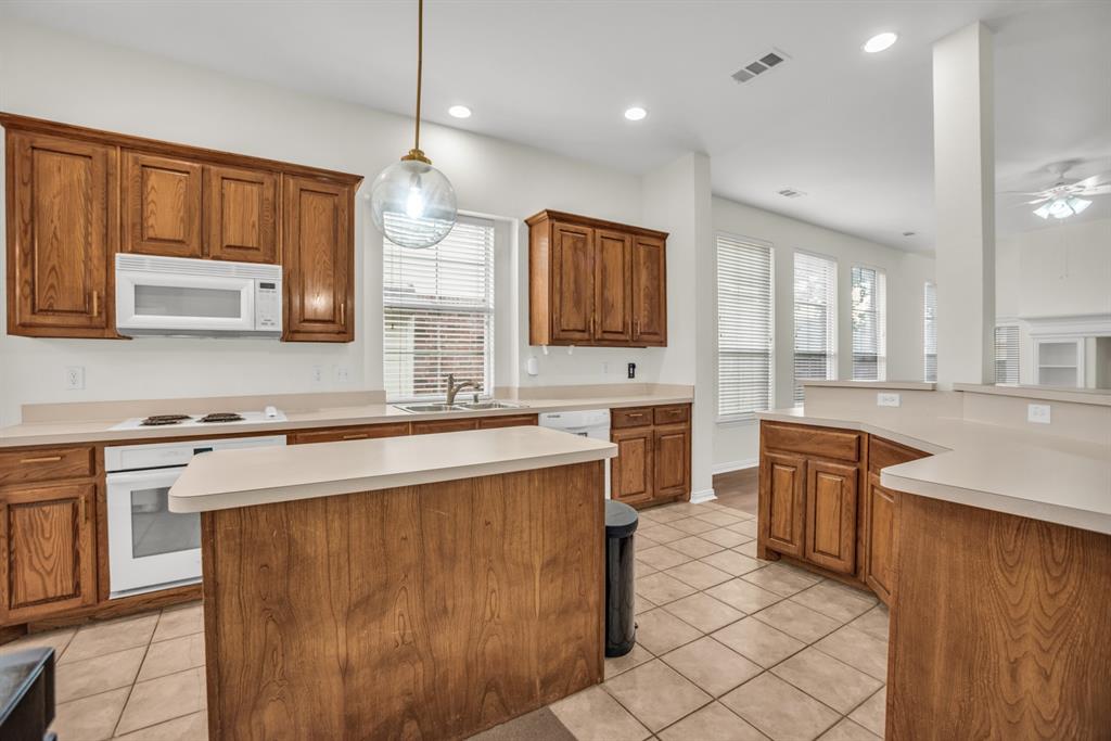 1610 Mapleleaf Falls Drive Allen, TX 75002 - Photo 11 of 36 a kitchen with stainless steel appliances granite countertop a sink stove and refrigerator