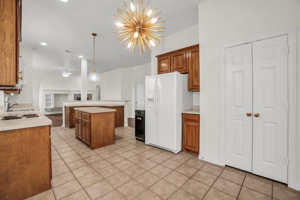 1610 Mapleleaf Falls Drive Allen, TX 75002 - Photo 13 of 36 a kitchen with stainless steel appliances a refrigerator a sink dishwasher with a dining table and chairs