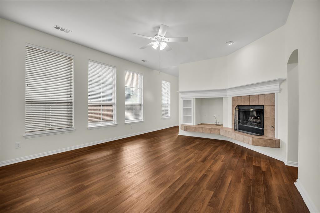 1610 Mapleleaf Falls Drive Allen, TX 75002 - Photo 15 of 36 a view of an empty room with wooden floor fireplace and a window
