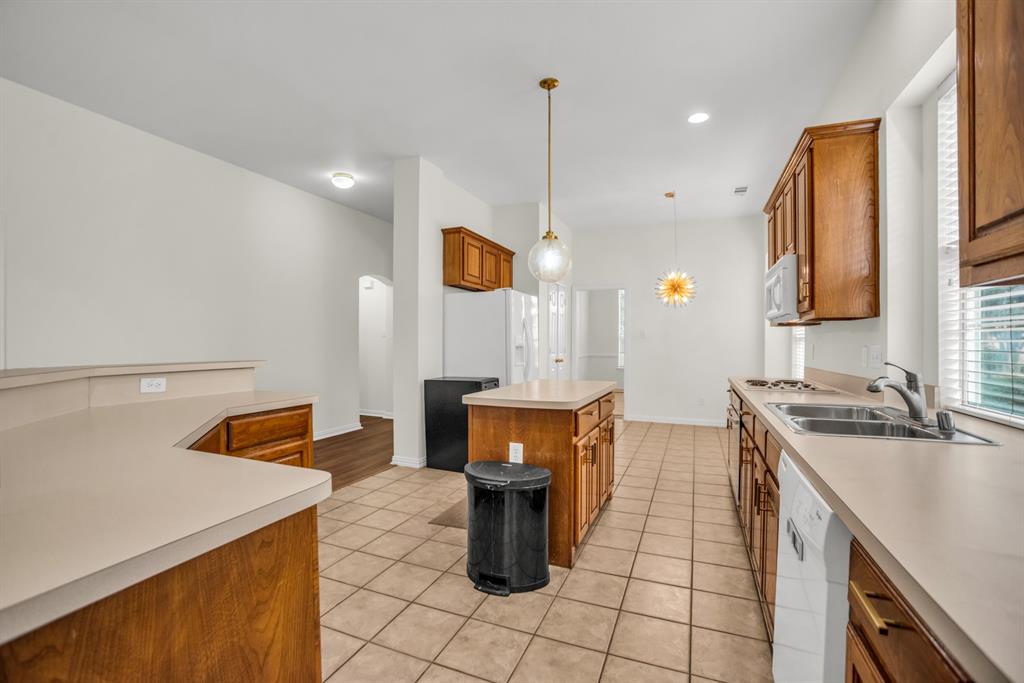 1610 Mapleleaf Falls Drive Allen, TX 75002 - Photo 10 of 36 a kitchen with a sink a stove and a wooden cabinets