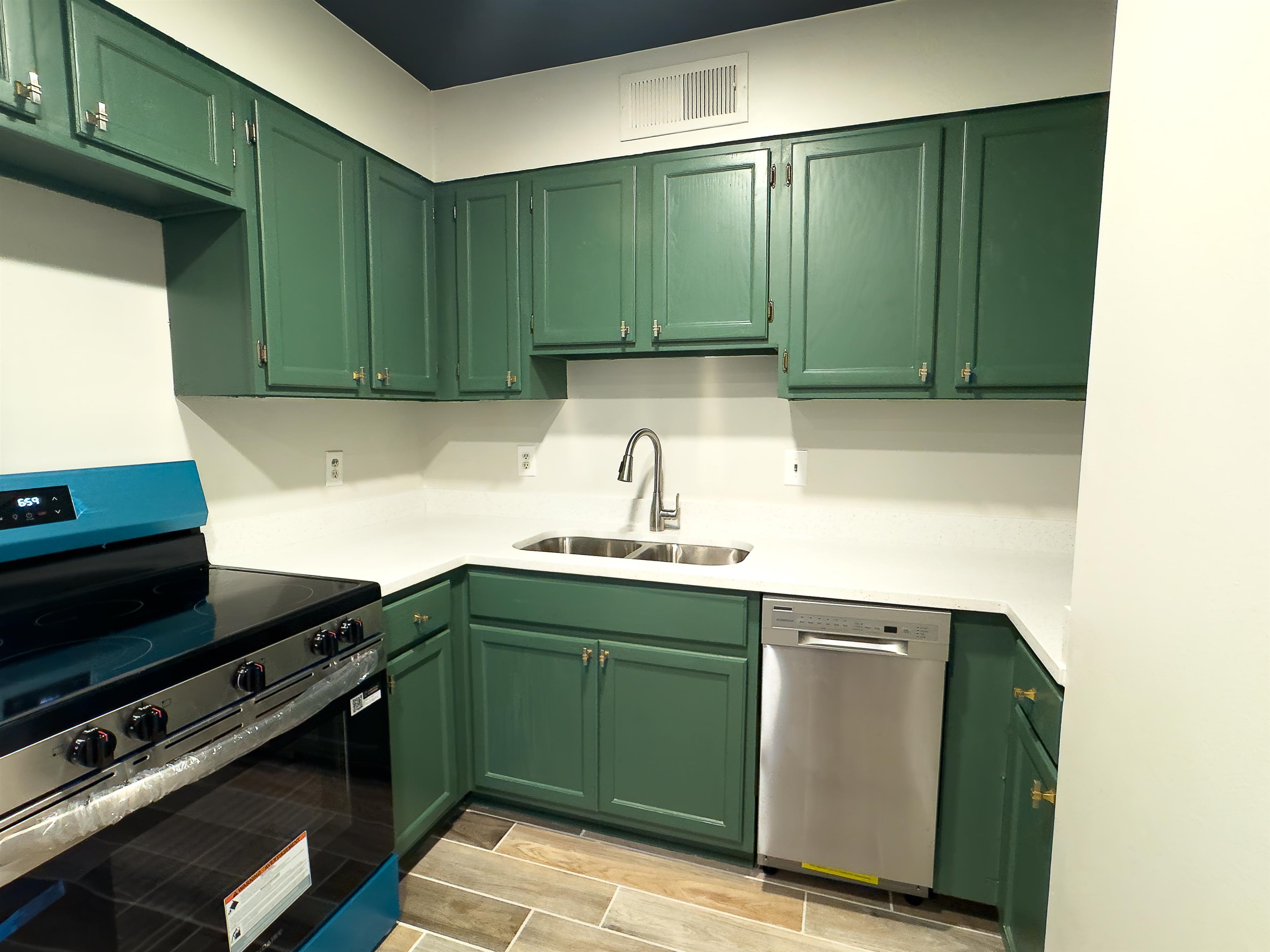 109 North Main Street, Unit 907 Memphis, TN 38103 - Photo 7 of 29 Kitchen featuring green cabinetry, white countertops, stainless steel sink, and wood-finish flooring