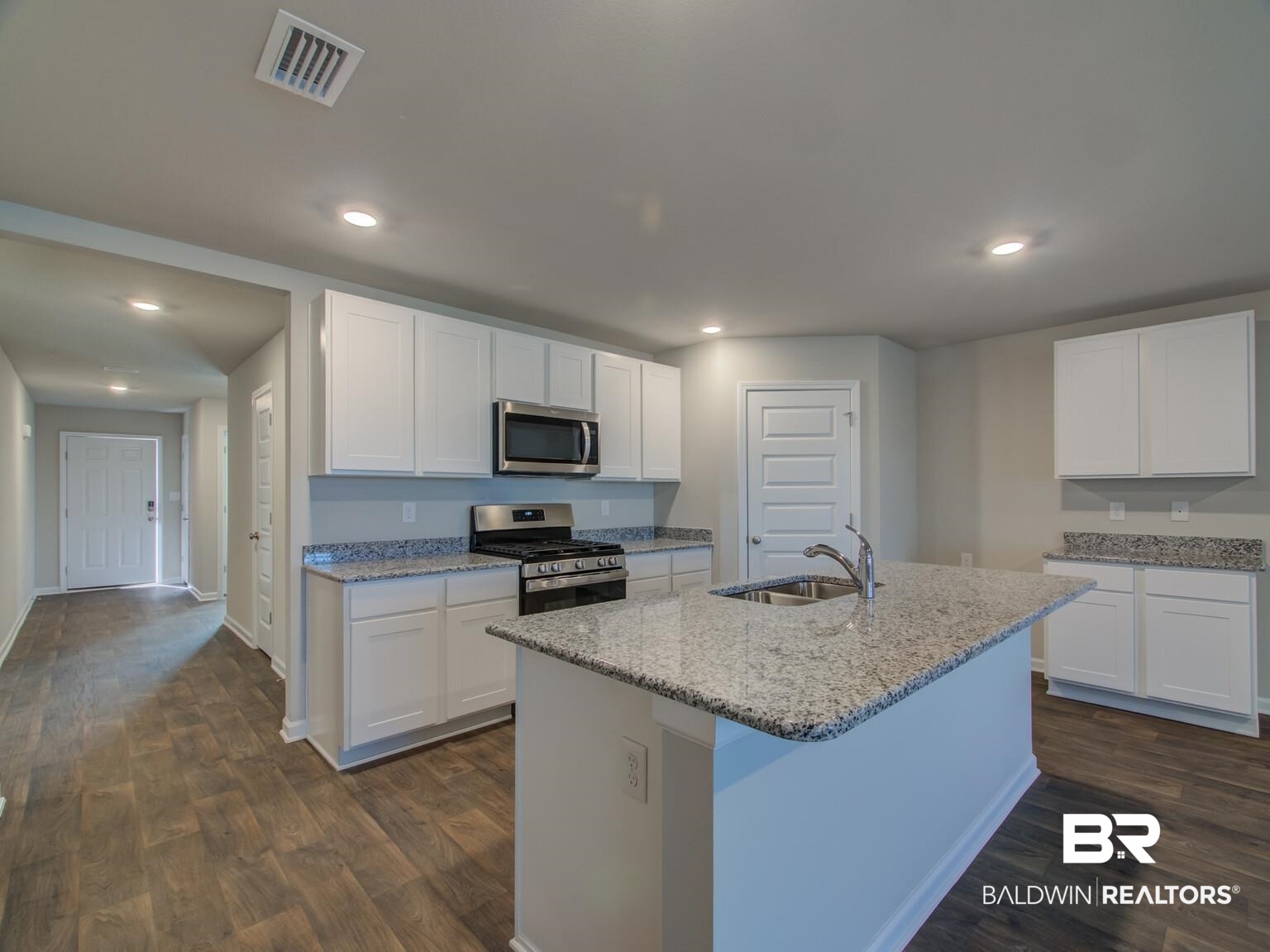 23952 Citation Loop Daphne, AL 36526 - Photo 14 of 69 Kitchen with white cabinetry, stainless steel appliances, light stone countertops, dark wood-style flooring, and an island with sink