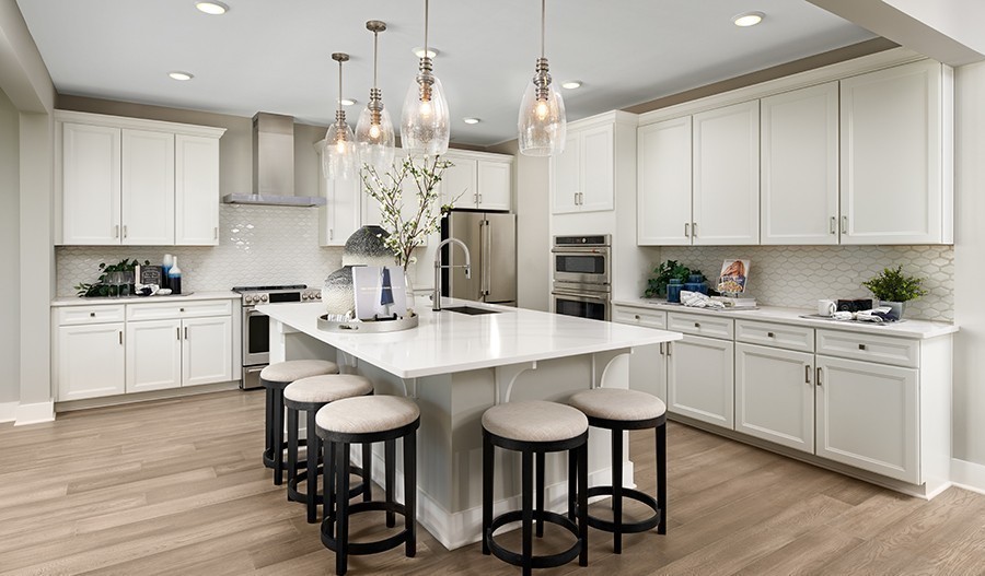 a kitchen with stainless steel appliances kitchen island a white table and chairs in it