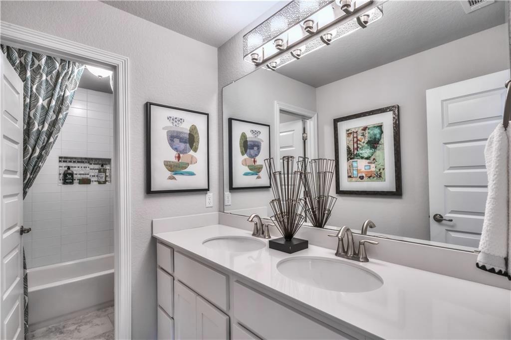 8605 Daisy Cutter Crossing Georgetown, TX 78626 - Photo 12 of 17 a bathroom with a tub a sink and mirror