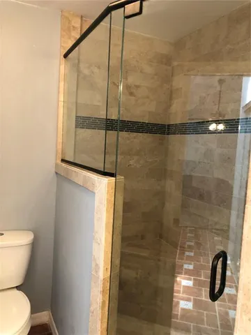a bathroom with a toilet and a shower