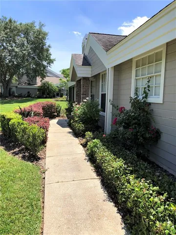 a front view of a house with a yard and potted plants