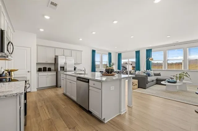 a kitchen with white cabinets and stainless steel appliances