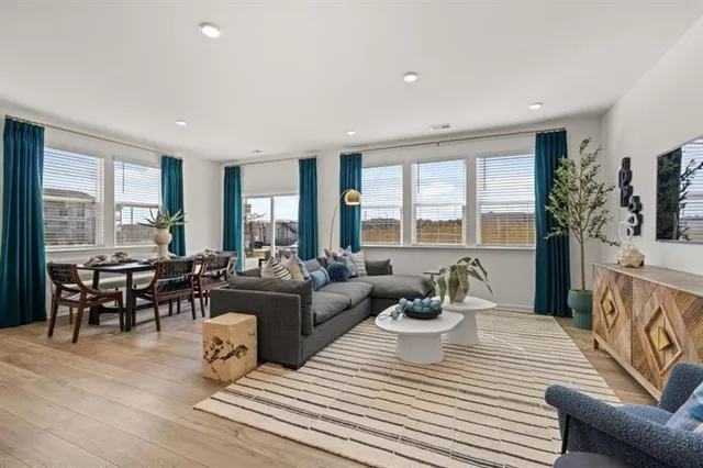 a living room with furniture a large window and a table