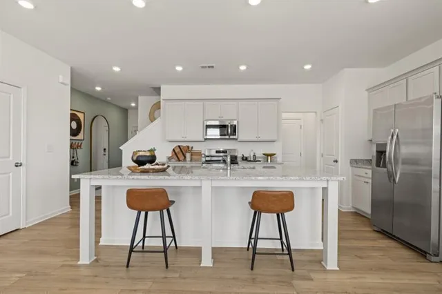 a kitchen with kitchen island a appliances a counter top space cabinets and stainless steel appliances