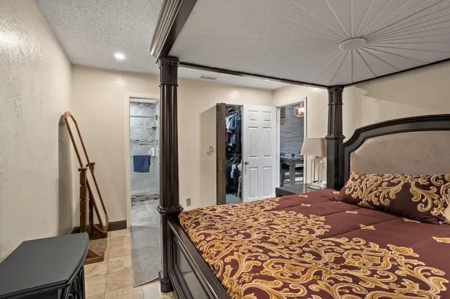 a bedroom with a large bed and a flat tv screen on dresser