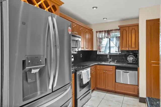 a kitchen with stainless steel appliances granite countertop a refrigerator and a sink