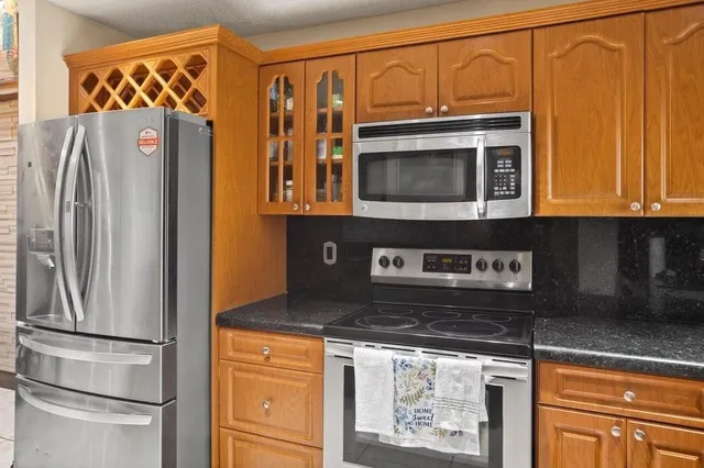 a kitchen with stainless steel appliances granite countertop a refrigerator and microwave