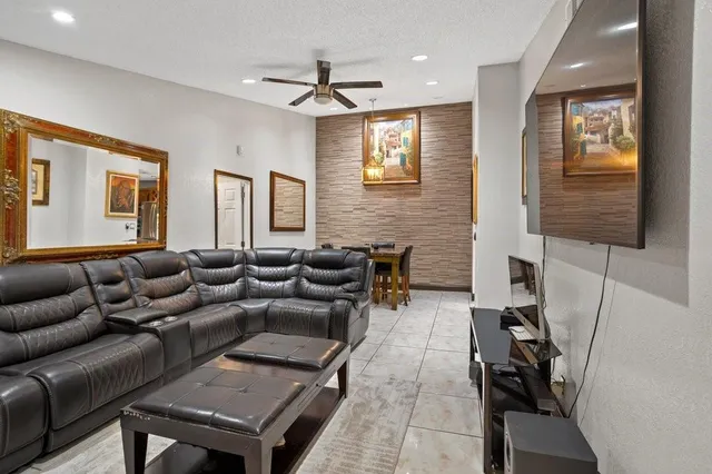 a living room with furniture a ceiling fan and a window