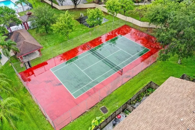 a view of a tennis ground with large trees