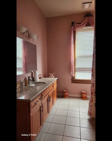 a bathroom with a sink vanity and a mirror