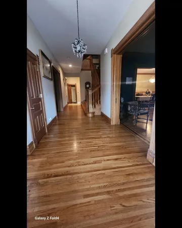 a view of a living room and chandelier with wooden floor