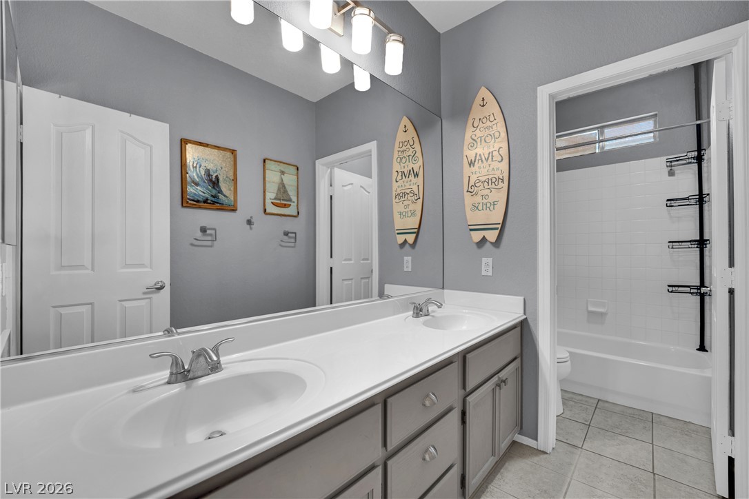 1724 Millstream Way Henderson, NV 89074 - Photo 26 of 60 Dual vanity sinks and a large mirror illuminate this well-appointed bathroom space.