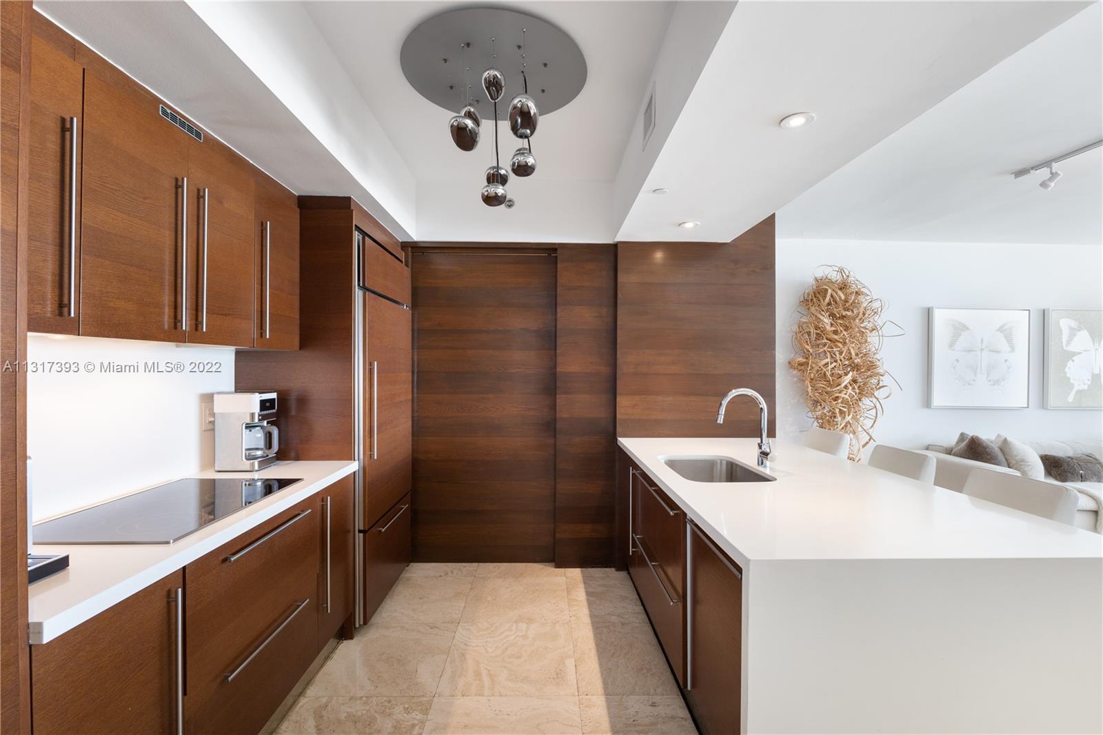 450 Alton Road, Unit 2706 Miami Beach, FL 33139 - Photo 12 of 53 a kitchen with a sink stainless steel appliances a counter space and cabinets