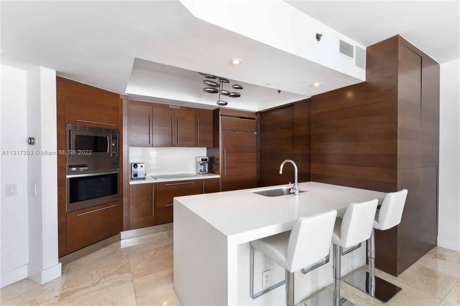 450 Alton Road, Unit 2706 Miami Beach, FL 33139 - Photo 13 of 53 a kitchen with a sink stainless steel appliances and cabinets