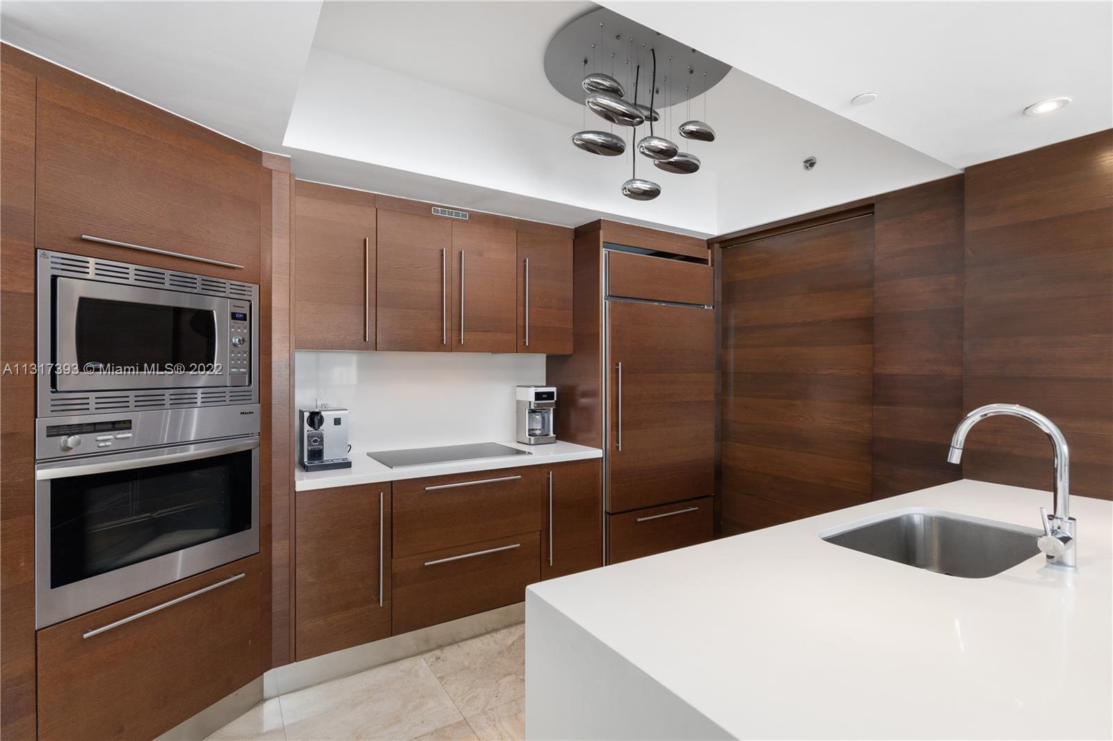 450 Alton Road, Unit 2706 Miami Beach, FL 33139 - Photo 14 of 53 a kitchen with a sink a stove and microwave