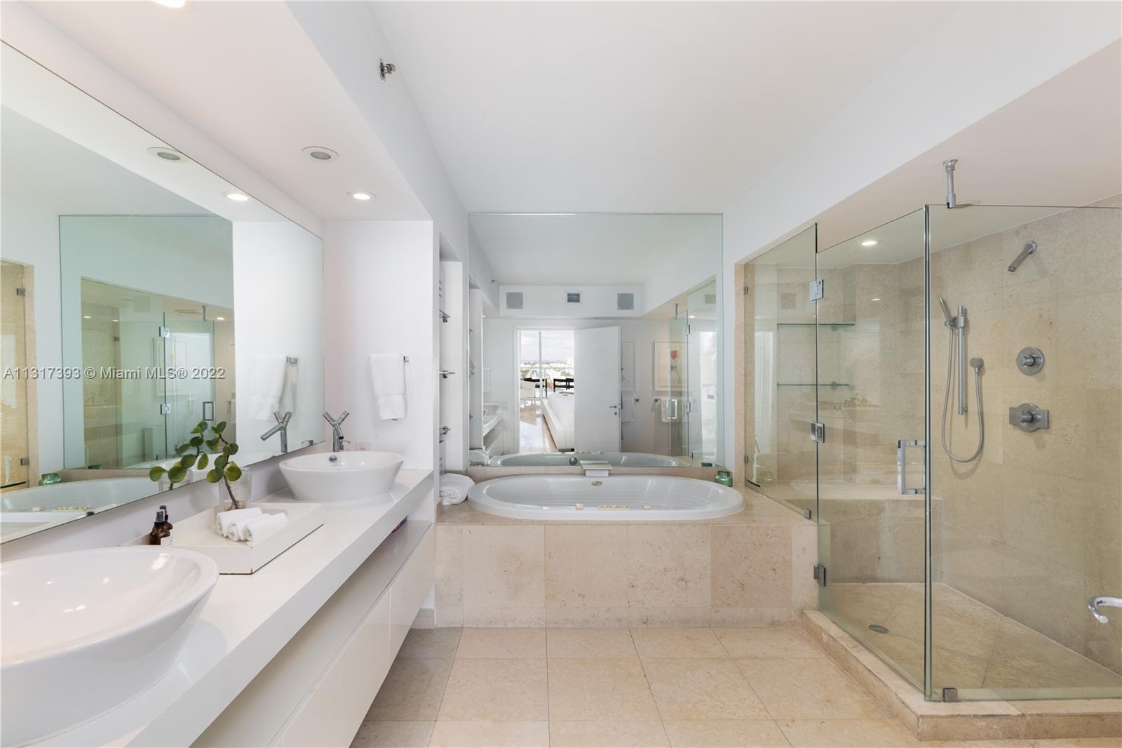 450 Alton Road, Unit 2706 Miami Beach, FL 33139 - Photo 20 of 53 a large white bathroom with a double vanity sink mirror and shower