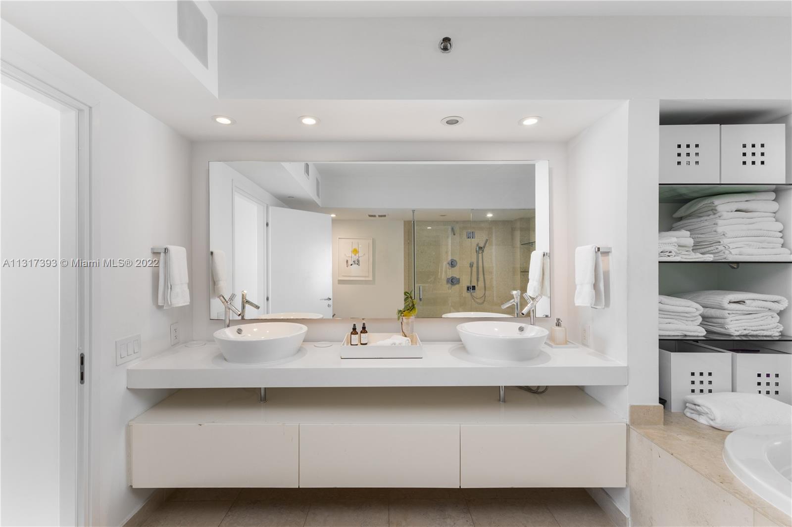 450 Alton Road, Unit 2706 Miami Beach, FL 33139 - Photo 21 of 53 a bathroom with double vanity sinks and a mirror