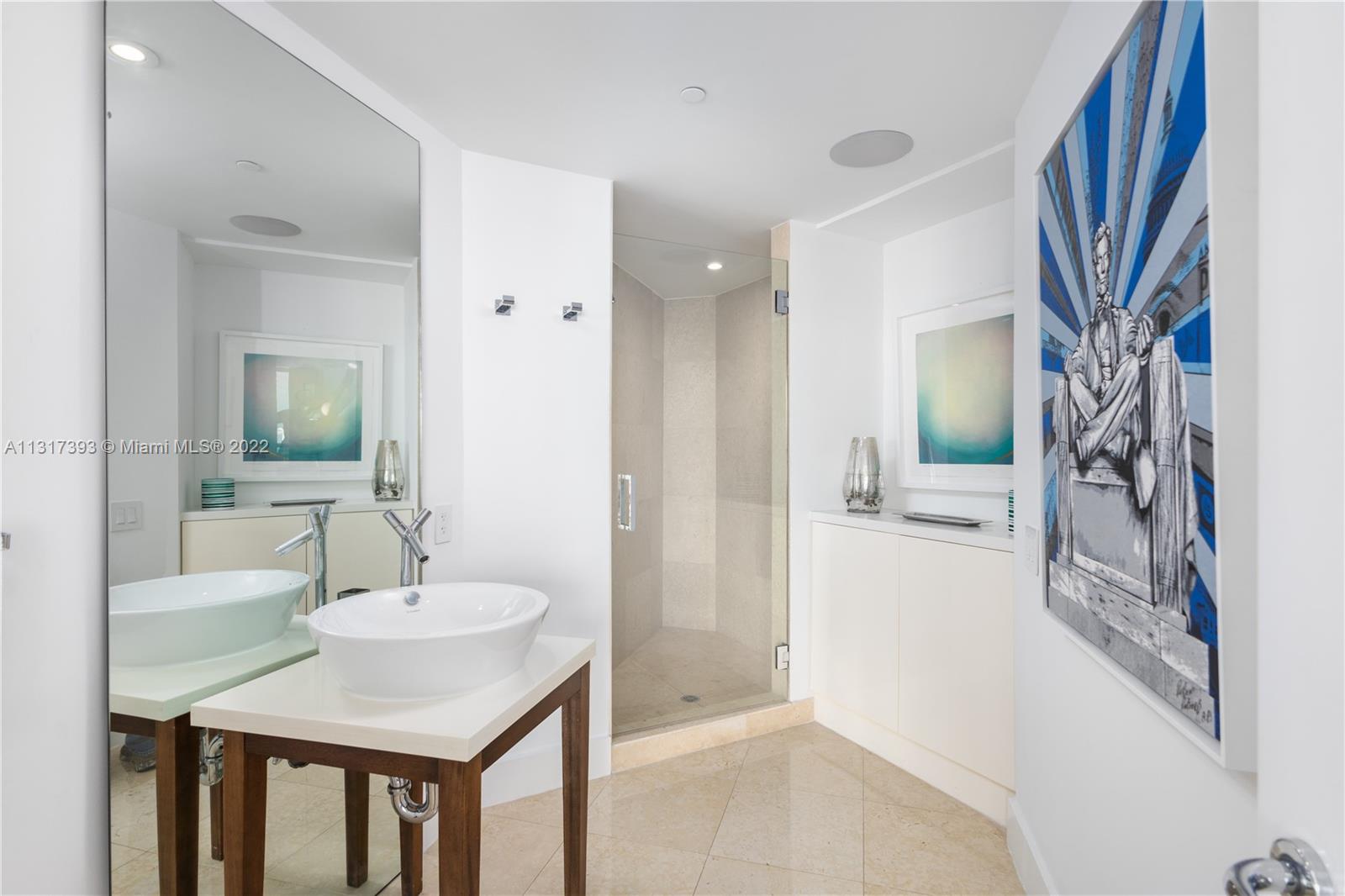 450 Alton Road, Unit 2706 Miami Beach, FL 33139 - Photo 26 of 53 a en suite bathroom with a sink a mirror and a shower