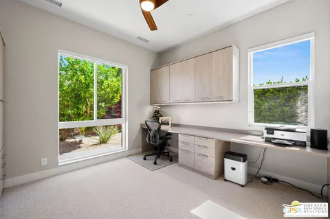 a view of a workspace with furniture and a window