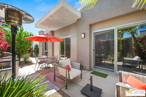 a view of a patio with a table and chairs under an umbrella