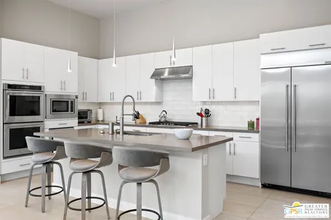 a kitchen with stainless steel appliances granite countertop a sink a stove and a refrigerator