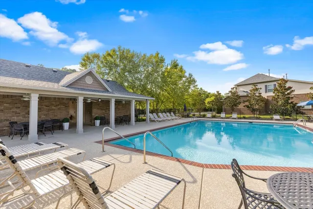 a view of a house with pool and sitting area