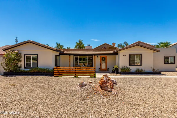 a front view of a house with a garden and patio