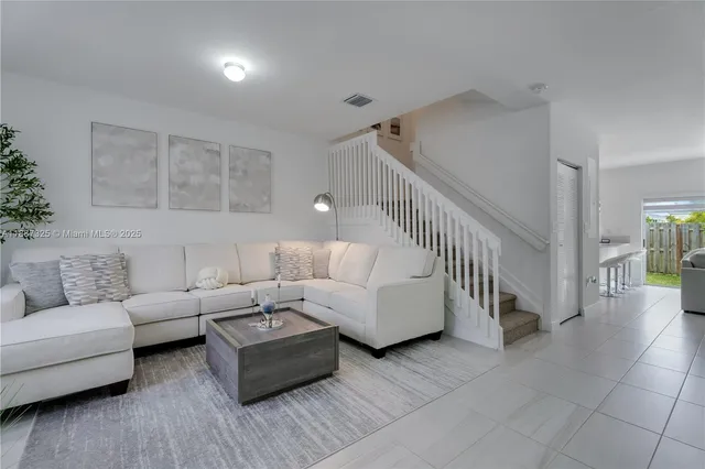 a living room with furniture and stairs