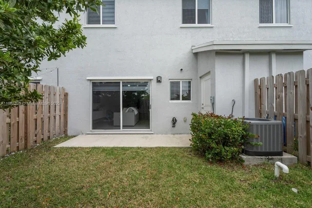 a view of house with backyard and glass windows