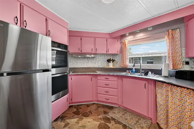 a kitchen with stainless steel appliances a refrigerator sink and cabinets