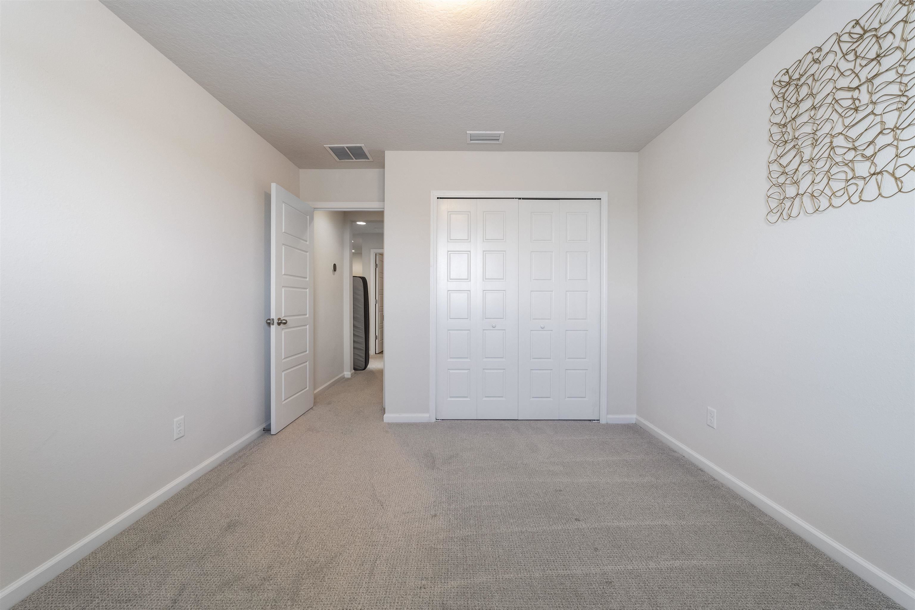 91 Pepperpike Way Street St. Augustine, FL 32092 - Photo 51 of 79 Unfurnished bedroom with carpet floors, a textured ceiling, and a closet