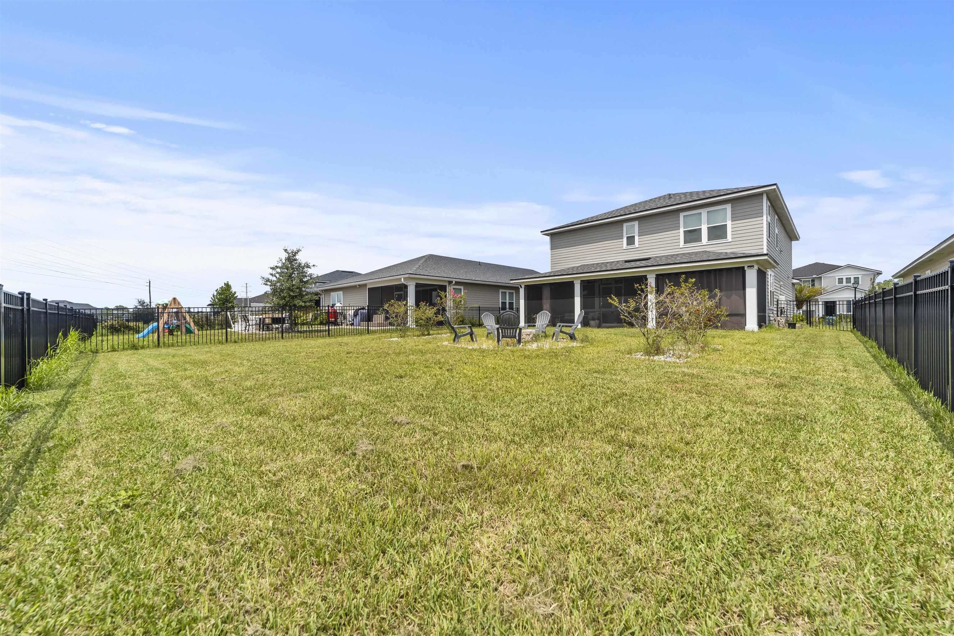 91 Pepperpike Way Street St. Augustine, FL 32092 - Photo 65 of 79 Back of house with a fenced backyard, a sunroom, and a playground