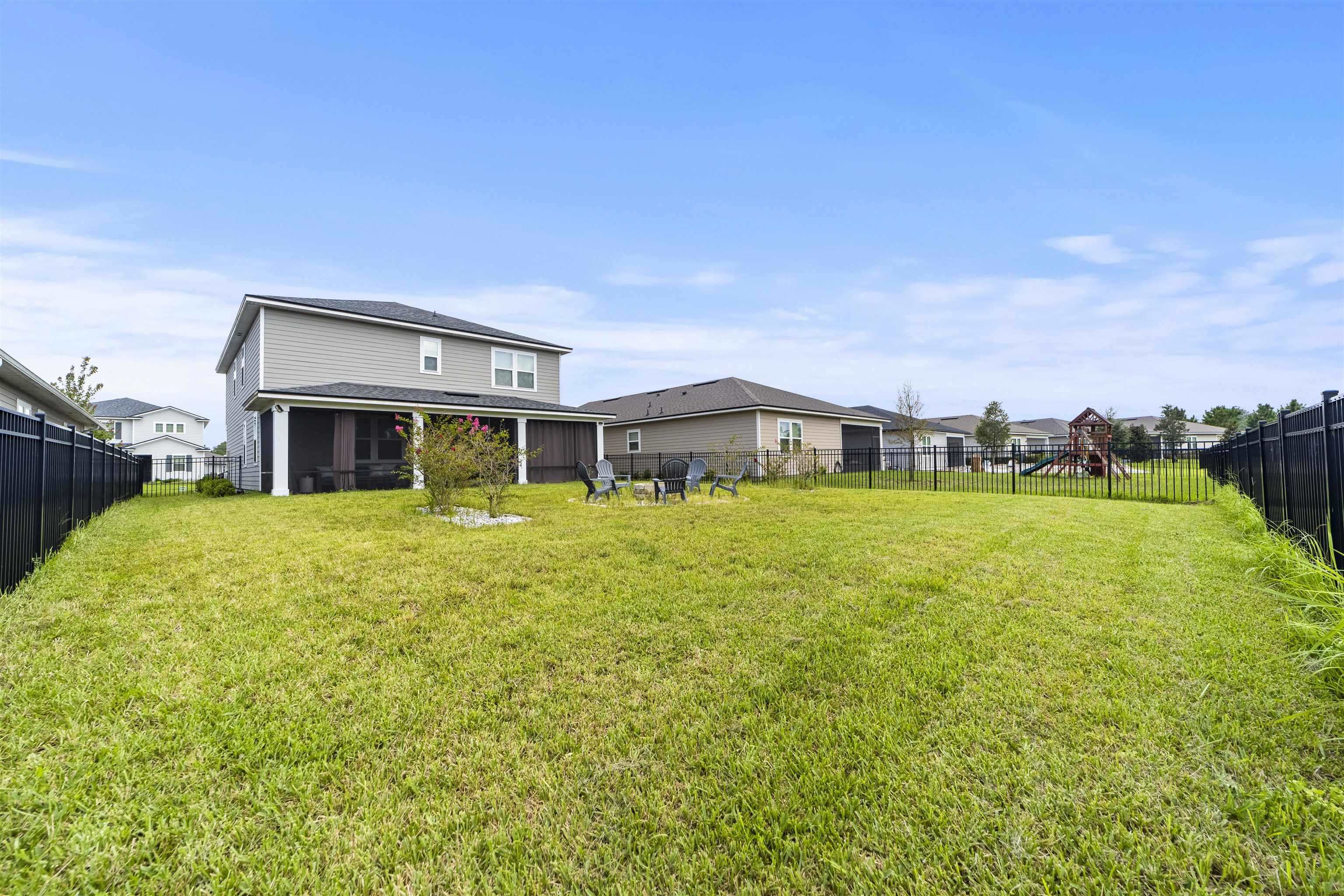 91 Pepperpike Way Street St. Augustine, FL 32092 - Photo 67 of 79 Rear view of property with a sunroom, a fenced backyard, and a playground